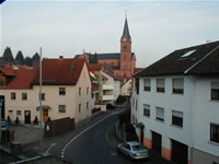 Das Foto basiert auf dem Bild "Straßenzug mit der katholischen Pfarrkirche St. Nikolaus in Goldbach" aus dem zentralen Medienarchiv Wikimedia Commons und steht unter der GNU-Lizenz für freie Dokumentation. Der Urheber des Bildes ist Maulaff.