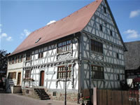 Das Foto basiert auf dem Bild "Ehem. Fronhof des Klosters Lobenfeld, Gebäude von 1718, heute Heimatmuseum" aus dem zentralen Medienarchiv Wikimedia Commons und ist lizenziert unter der Creative Commons-Lizenz Attribution ShareAlike 2.5. Der Urheber des Bildes ist p.schmelzle.