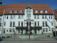 Das Foto basiert auf dem Bild "Das neuerbaute Rathaus" aus dem zentralen Medienarchiv Wikimedia Commons und steht unter der GNU-Lizenz für freie Dokumentation. Der Urheber des Bildes ist Manecke.