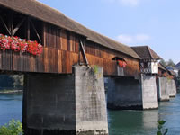 Das Foto basiert auf dem Bild "Holzbrücke Bad Säckingen, Richtung Stein (Schweiz) gesehen" aus der freien Enzyklopädie Wikipedia und steht unter der GNU-Lizenz für freie Dokumentation. Der Urheber des Bildes ist Wladyslaw.